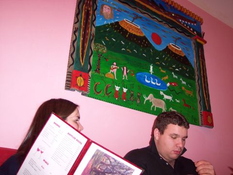 2001 Ford Crown Victoria - People review a menu at a table, with a large, vibrant painting on the wall behind them.