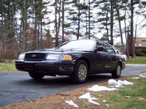2001 Ford Crown Victoria - A dark Ford Crown Victoria is parked on a driveway with patchy snow on the ground.