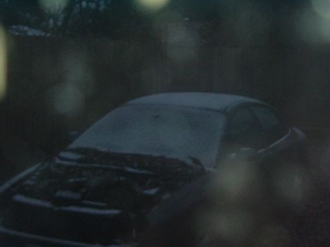 1993 Ford Taurus - A dark sedan sits covered in snow with its hood open, viewed from the front.