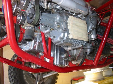 1993 Ford Taurus - The engine bay of a custom vehicle features a complex drivetrain with polished metal components and a red roll cage.