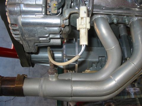 1993 Ford Taurus - Close-up view of engine components including the exhaust manifold and alternator.