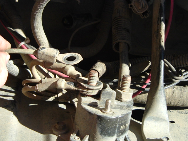 Dusty starter solenoid with copper terminal studs and ring-terminal cables