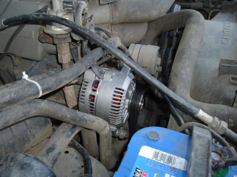 1989 Ford Bronco - A new alternator is installed in the engine bay, surrounded by various hoses and wiring.