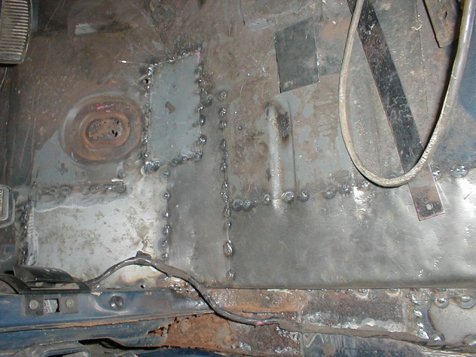 Underside floor pan with multiple welded sheet metal patches and stitch welds