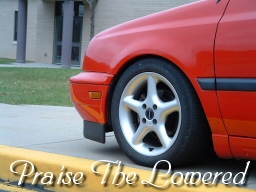 1994 Volkswagen Jetta - Close-up of a lowered red car's front fender and wheel.