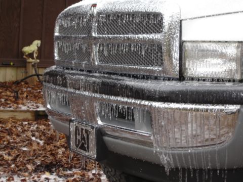 1989 Ford Bronco - A truck's front end is encased in ice, with icicles dripping from the grille and bumper.
