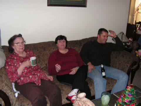 1978 Ford Bronco - A holiday gathering shows three individuals seated on a patterned couch, with one holding a mug and another a bottle.