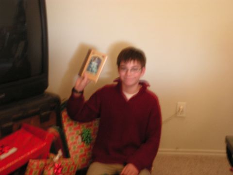 1978 Ford Bronco - A young boy proudly displays a framed picture while surrounded by holiday gifts.