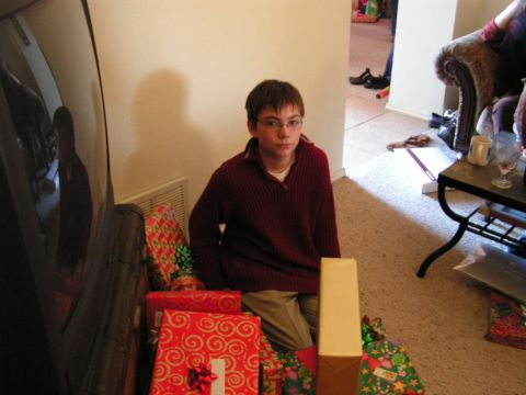 1978 Ford Bronco - A young boy sits on the floor, surrounded by Christmas presents, with a large black object to his left.
