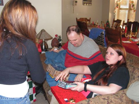 1978 Ford Bronco - A group of people are gathered in a living room, opening gifts around a Christmas tree.