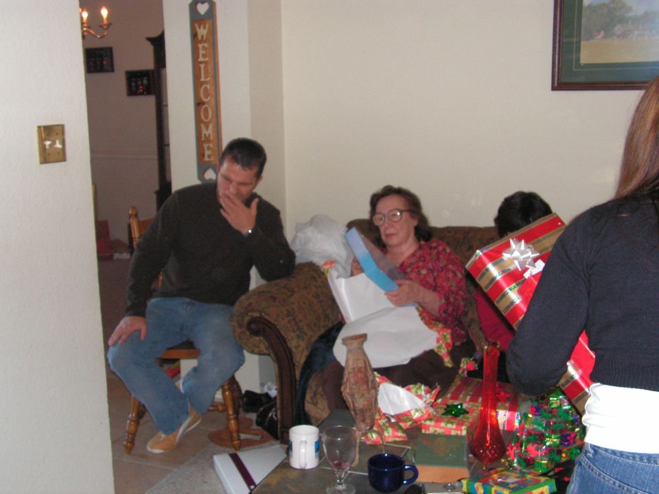 People opening Christmas gifts in a living room