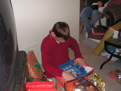 1978 Ford Bronco - A person unwraps a Christmas gift while sitting on the floor surrounded by presents.