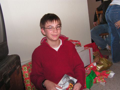 1978 Ford Bronco - A young boy smiles while holding a booklet amidst a pile of Christmas presents.