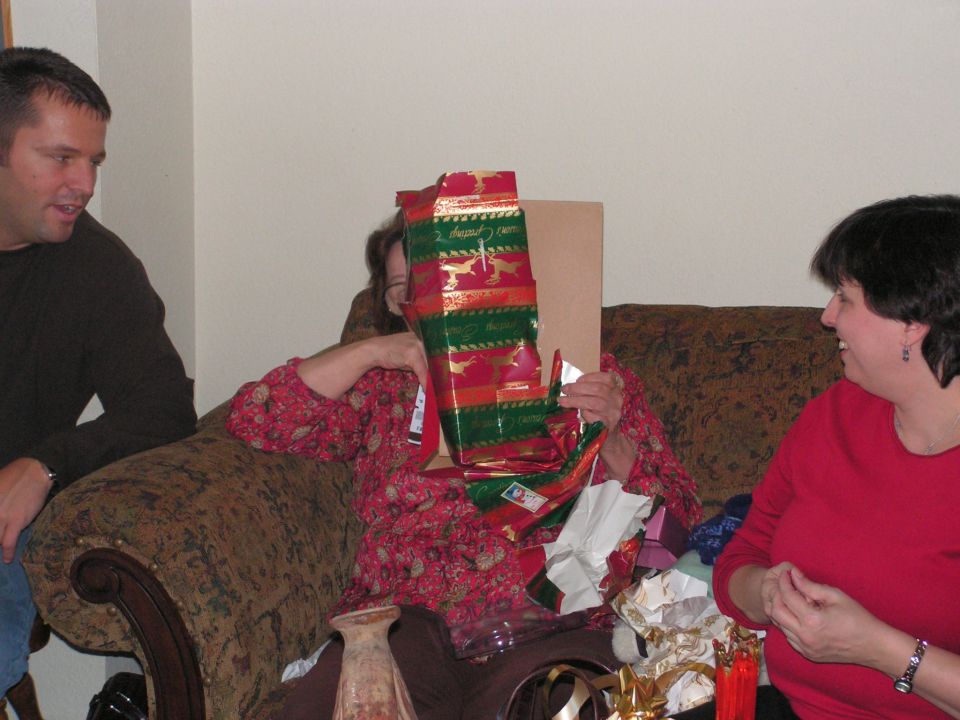 People opening Christmas gifts on a couch
