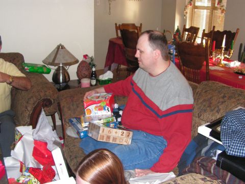 1978 Ford Bronco - A man sits on a couch surrounded by wrapped presents and opened gift boxes.