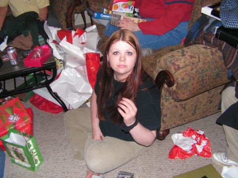 1978 Ford Bronco - A woman sits on the floor amidst a pile of Christmas presents and furniture, looking towards the camera.