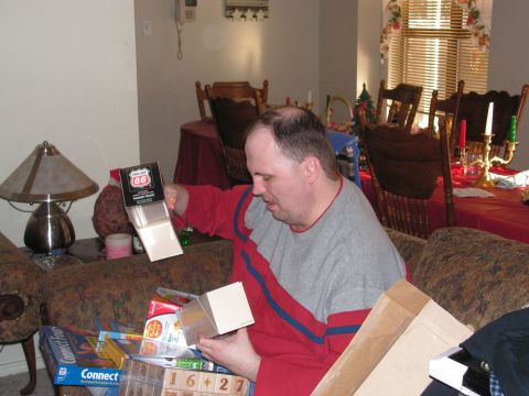 1978 Ford Bronco - Man opens a gift box with a Phillips 66 logo, surrounded by other presents and board games.