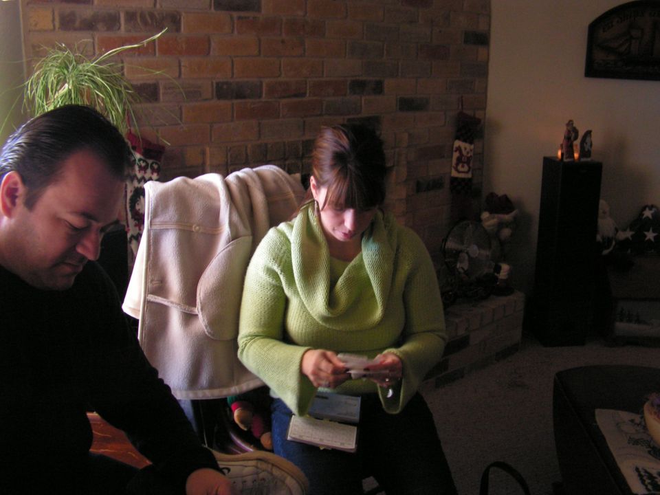 Man and woman sitting in a living room, looking at papers