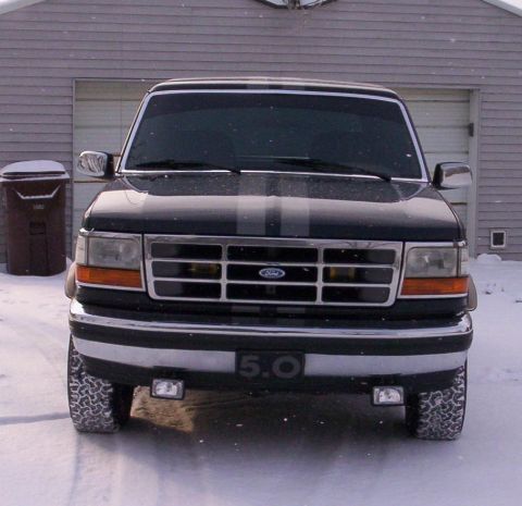 1993 Ford Bronco - This 1993 Ford Bronco is seen from the front in a snowy setting, racing stripes and a 5.0 badge.