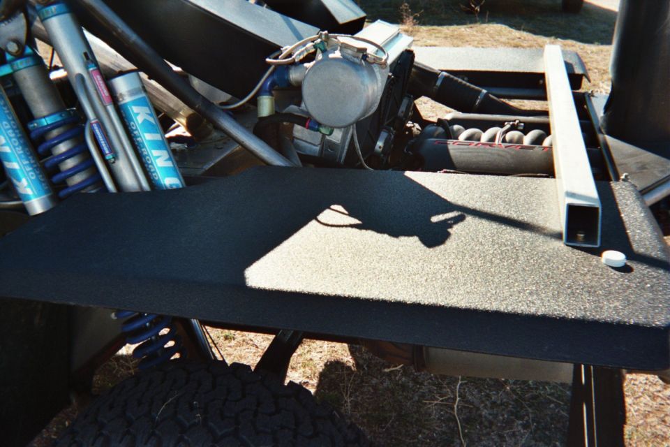 Tube-chassis vehicle with King bypass shocks and a flat black platform deck