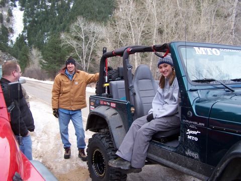 1985 Ford Bronco - A group of people pose with a Jeep Wrangler in a snowy, wooded area.