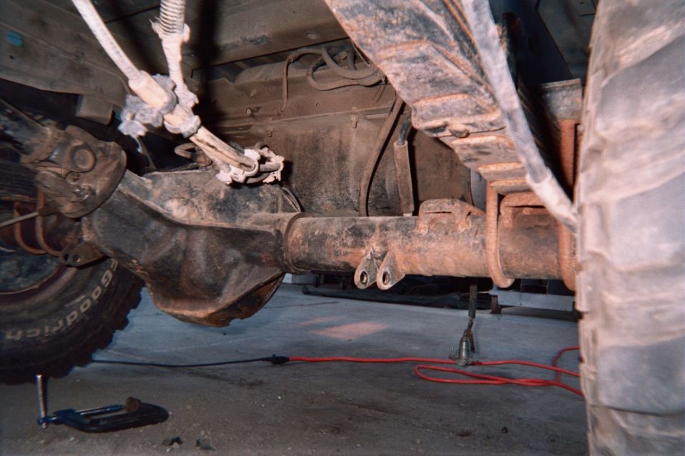 Undercarriage showing front axle, differential and exhaust pipe of a vehicle on jack stands