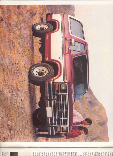 1985 Ford Bronco - A two-tone Ford Bronco is shown from a three-quarter front view, parked on a rocky incline.