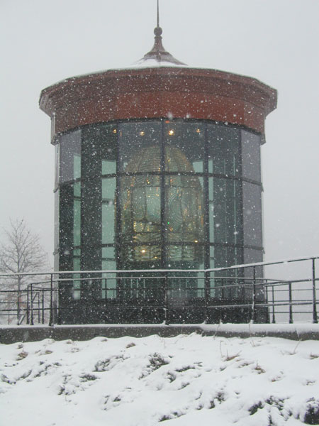1988 Ford Bronco - A lighthouse stands tall amidst falling snow.