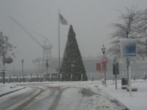 1988 Ford Bronco - A winter scene with a decorated Christmas tree and an American flag during a snowfall, snowstorm.