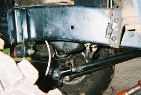 1978 Ford Bronco - Close-up view of the undercarriage, focusing on the suspension and steering system of a vehicle.
