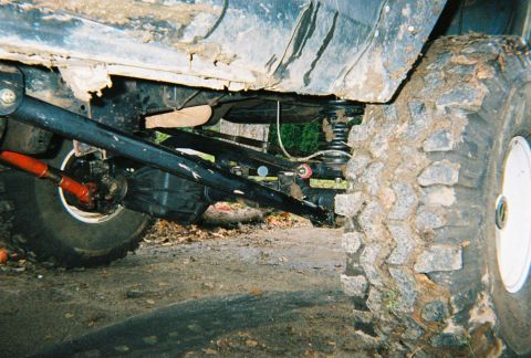 1978 Ford Bronco - Close-up of the suspension and tire of a heavily modified off-road vehicle.