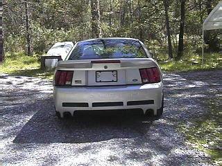 2002 Ford Mustang - The rear of a silver 2002 Ford Mustang is shown parked outdoors.