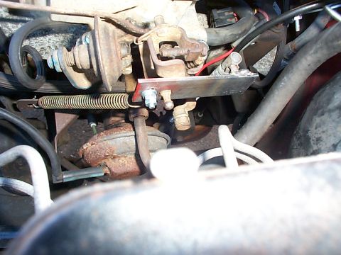1989 Jeep YJ - Close-up view of engine components, including a carburetor and throttle linkage.