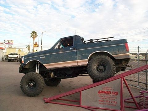 1994 Ford Bronco - A lifted 1994 Ford Bronco is positioned on a ramp, its off-road capabilities.
