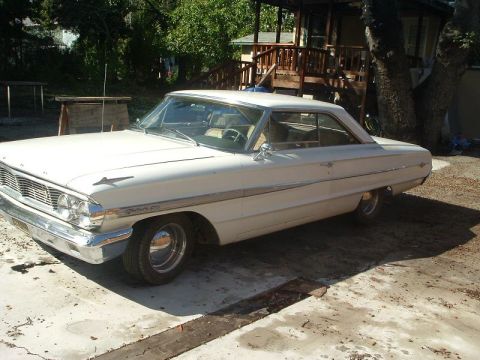 1964 Ford Galaxie - A white 1964 Ford Galaxie 500 coupe is seen from a 3/4 front angle in a driveway.