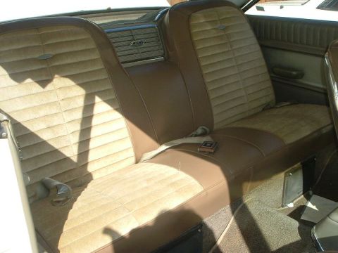 1964 Ford Galaxie - The rear interior of a 1964 Ford Galaxie XL500 features brown velour and vinyl seats with lap belts.