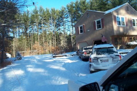 2001 Ford Crown Victoria - A white SUV is parked in a snowy driveway next to a house, with another dark car visible behind it.