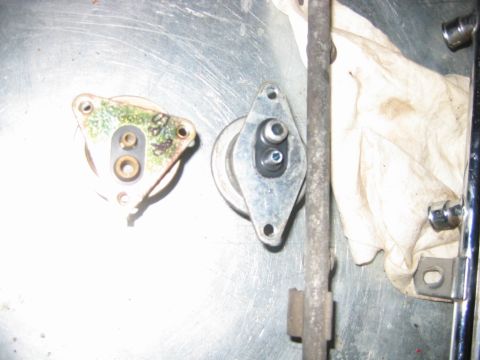 1992 Ford Bronco - Two automotive parts are laid out on a metallic surface next to a rag and some metal rods.