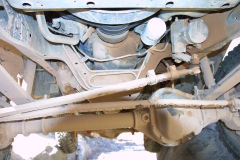 1987 Ford Bronco - This photo shows the underside of a 4x4 vehicle, focusing on the front axle and steering assembly.