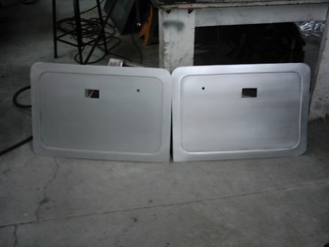 1978 Ford Bronco - A pair of silver door panels, likely for a classic vehicle, are shown laid out on a concrete floor.