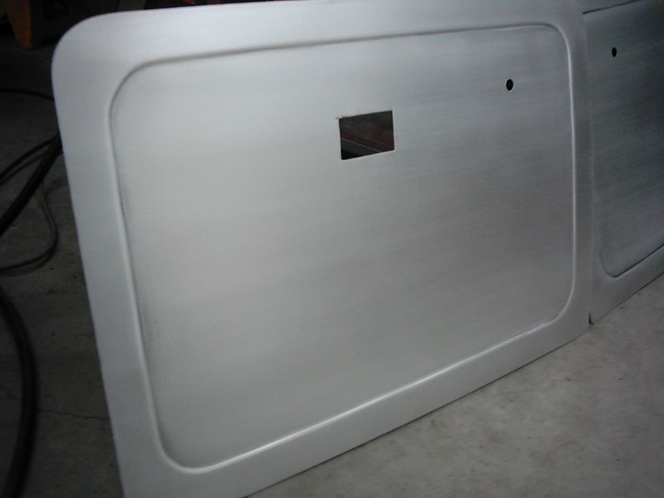Close-up of a brushed aluminum door panel with a square cutout