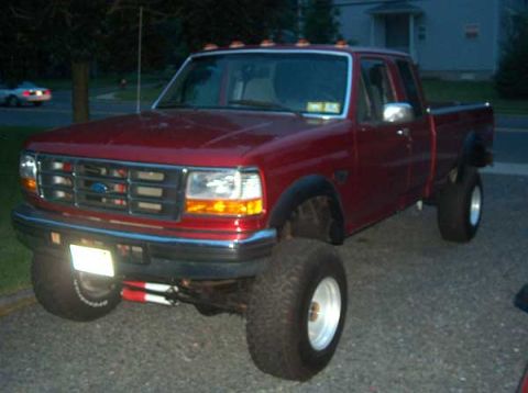 1996 Ford F-250 - Red 1996 Ford F-250 pickup truck with aftermarket wheels and tires.