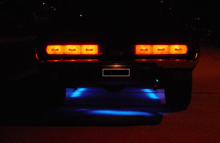 Rear of vehicle at night with two triple-segment LED taillights lit and blue underglow