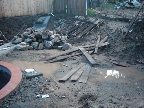 1978 Ford Bronco - A scene of construction debris, including lumber and rocks, scattered across a muddy area with several puddles.