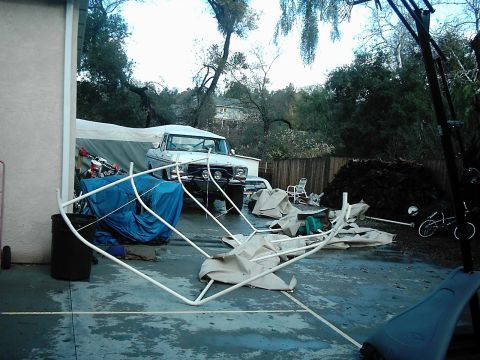 1978 Ford Bronco - A white pickup truck, likely from the early 1970s, is parked in a cluttered driveway. The vehicle has a prominent grille and aftermarket bu…