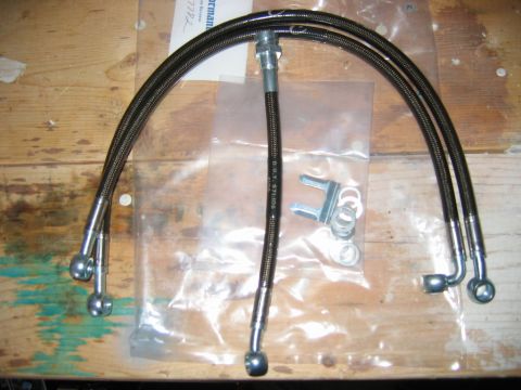 1985 Ford LTD Crown Victoria - Braided brake lines and hardware laid out on a wooden surface.
