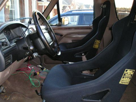 1996 Ford Bronco - Interior view of a 1996 Ford Bronco, Sparco racing seats and visible wiring under the dashboard.