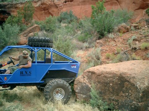1979 Ford Bronco - A custom blue off-road buggy navigates a rocky trail.