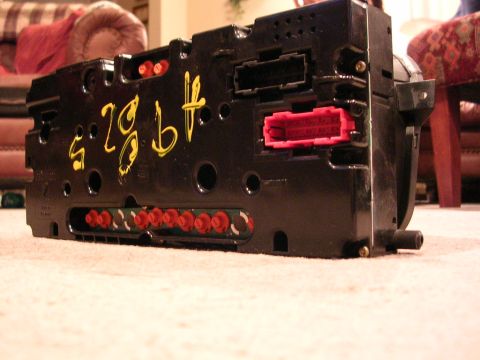 2003 Chevrolet Monte Carlo - A black electronic module with multiple red connectors and yellow handwritten markings is shown.