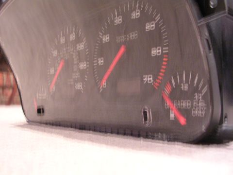 2003 Chevrolet Monte Carlo - Close-up of vehicle dashboard gauges, including speedometer and fuel indicator, with red needles.